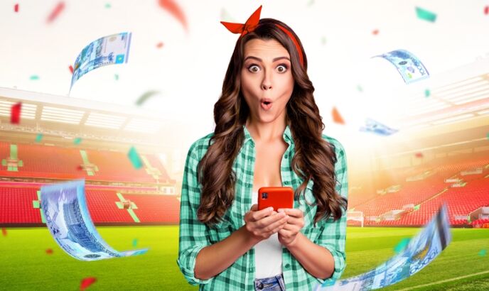 Девушка с мобильным телефоном на фоне футбольного стадиона